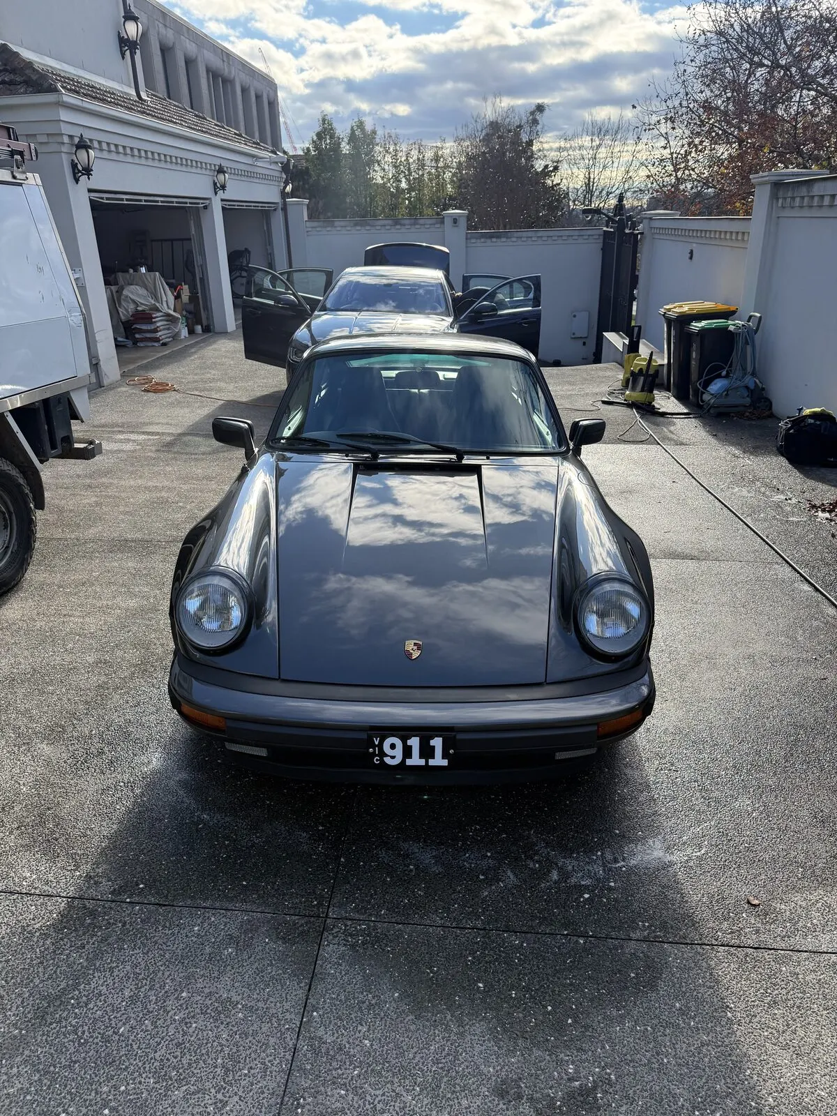 Classic dark grey Porsche 911 freshly detailed in a driveway